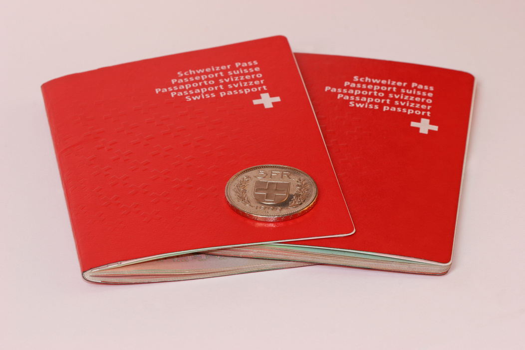 Two Swiss passports with coin